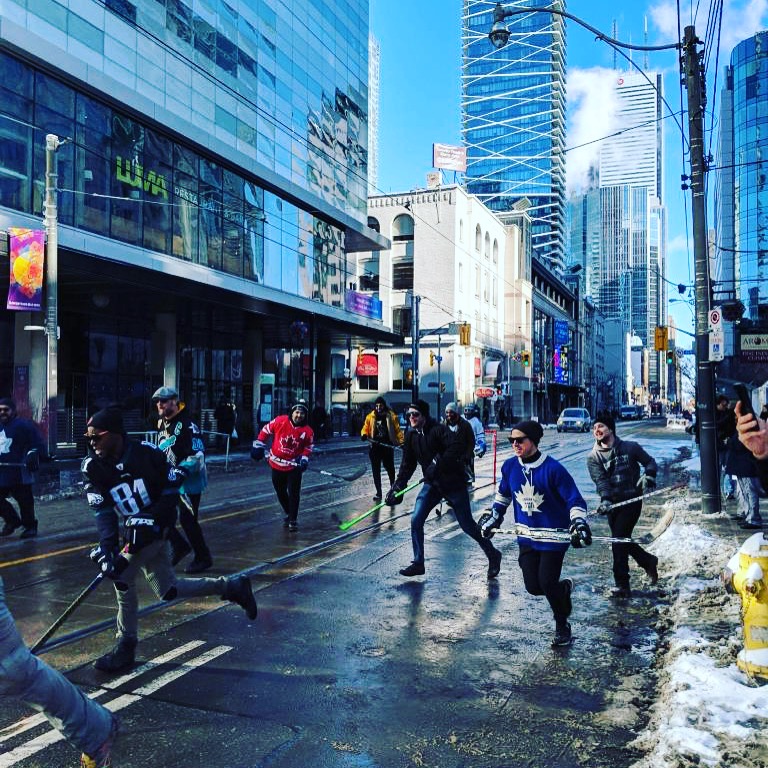People playing road hockey on King Street, Toronto